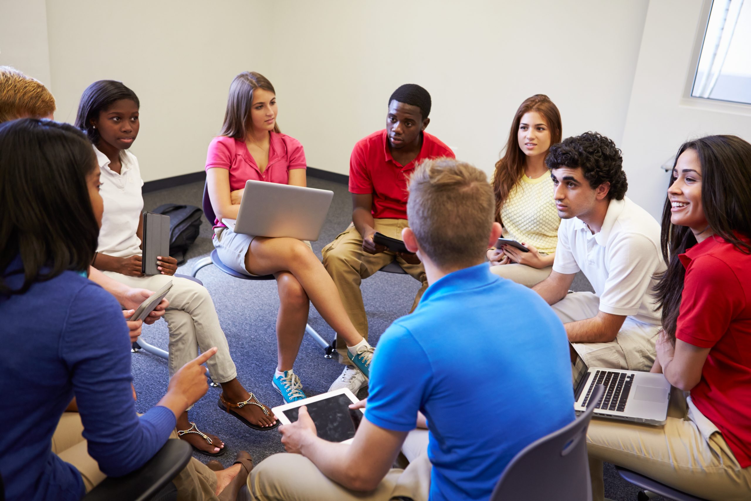 Secondary education school students actively participating in a group discussion.