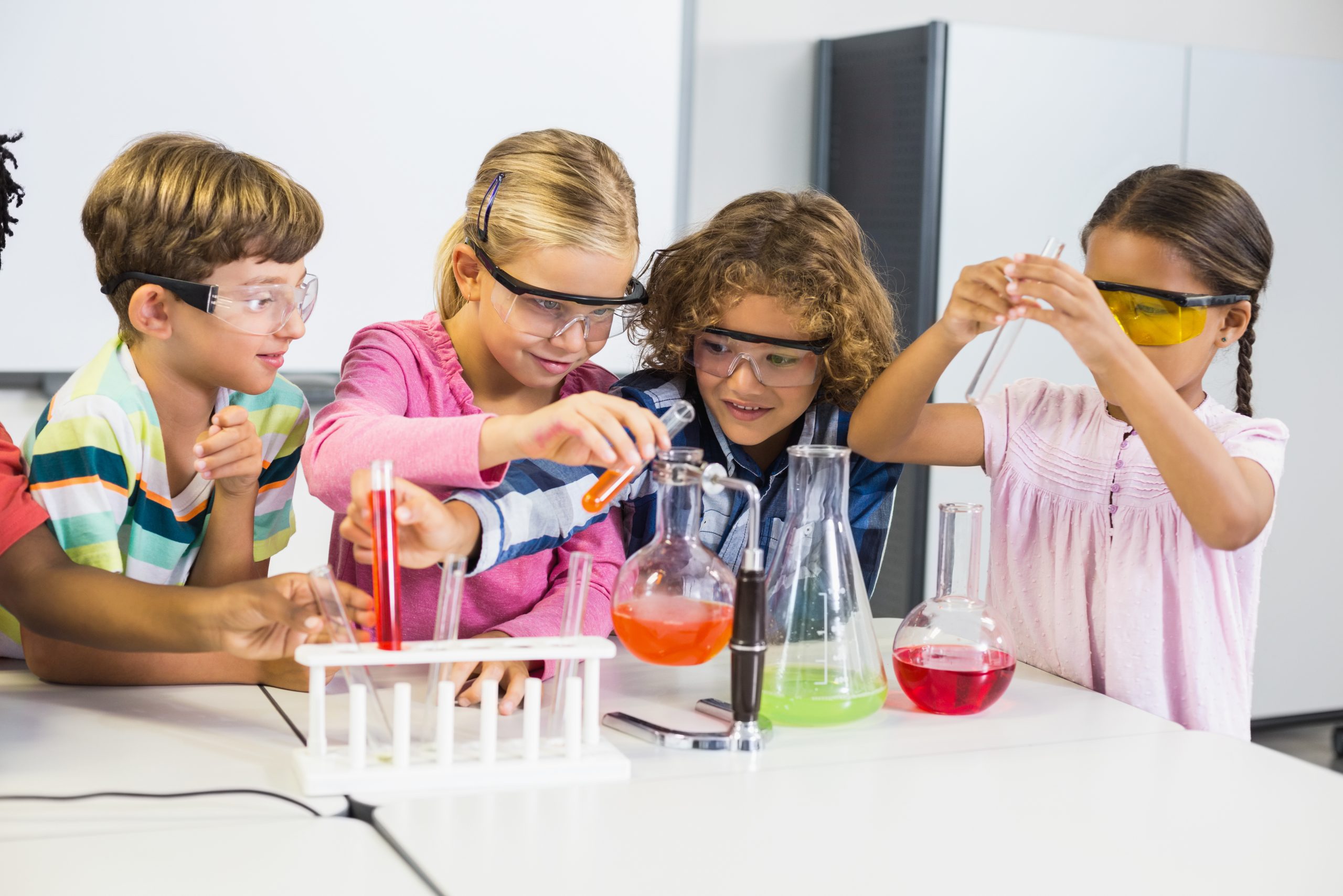 Kids in school laboratory engaged in a chemical experiment.