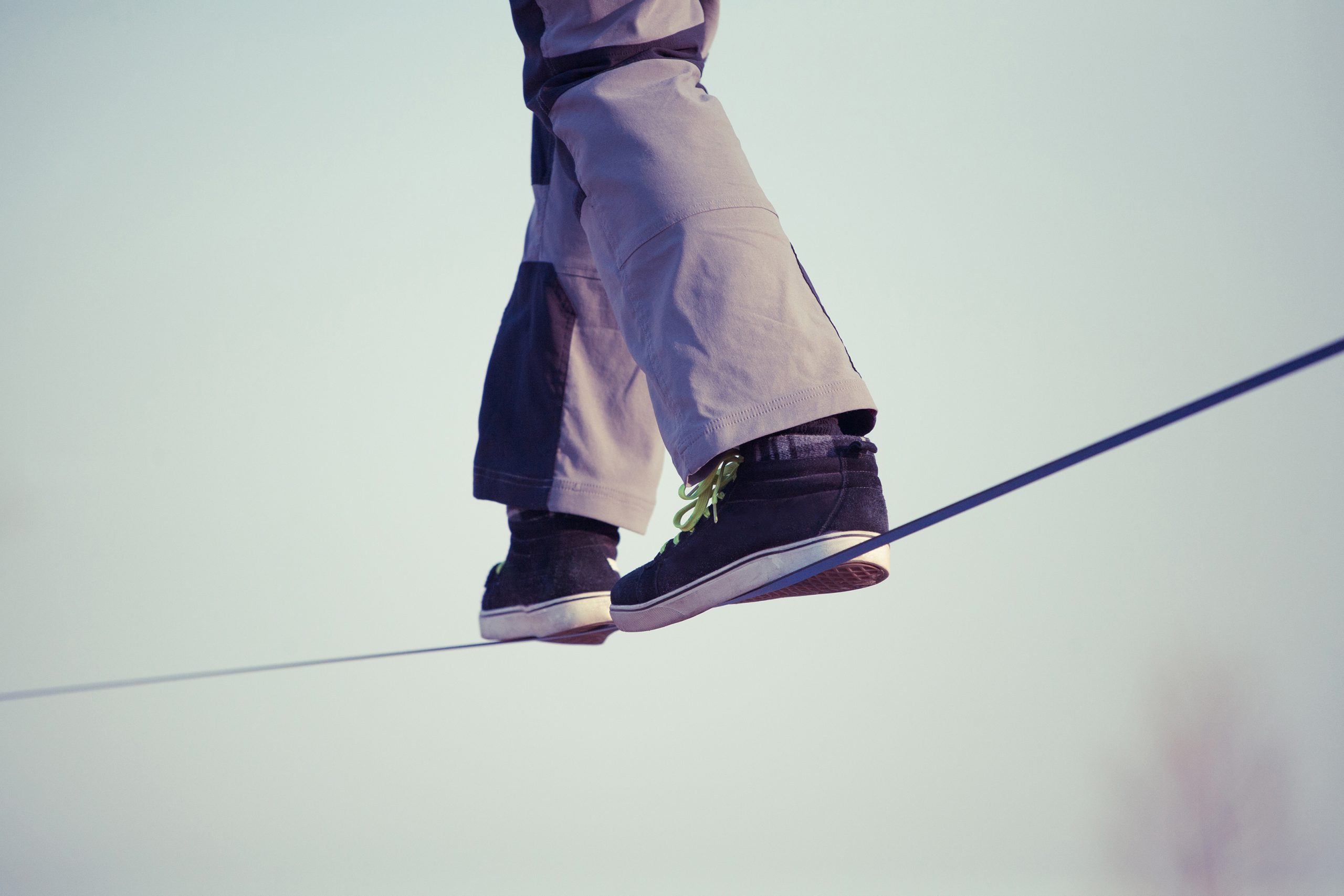 Man balancing and walking on a tight slackline.