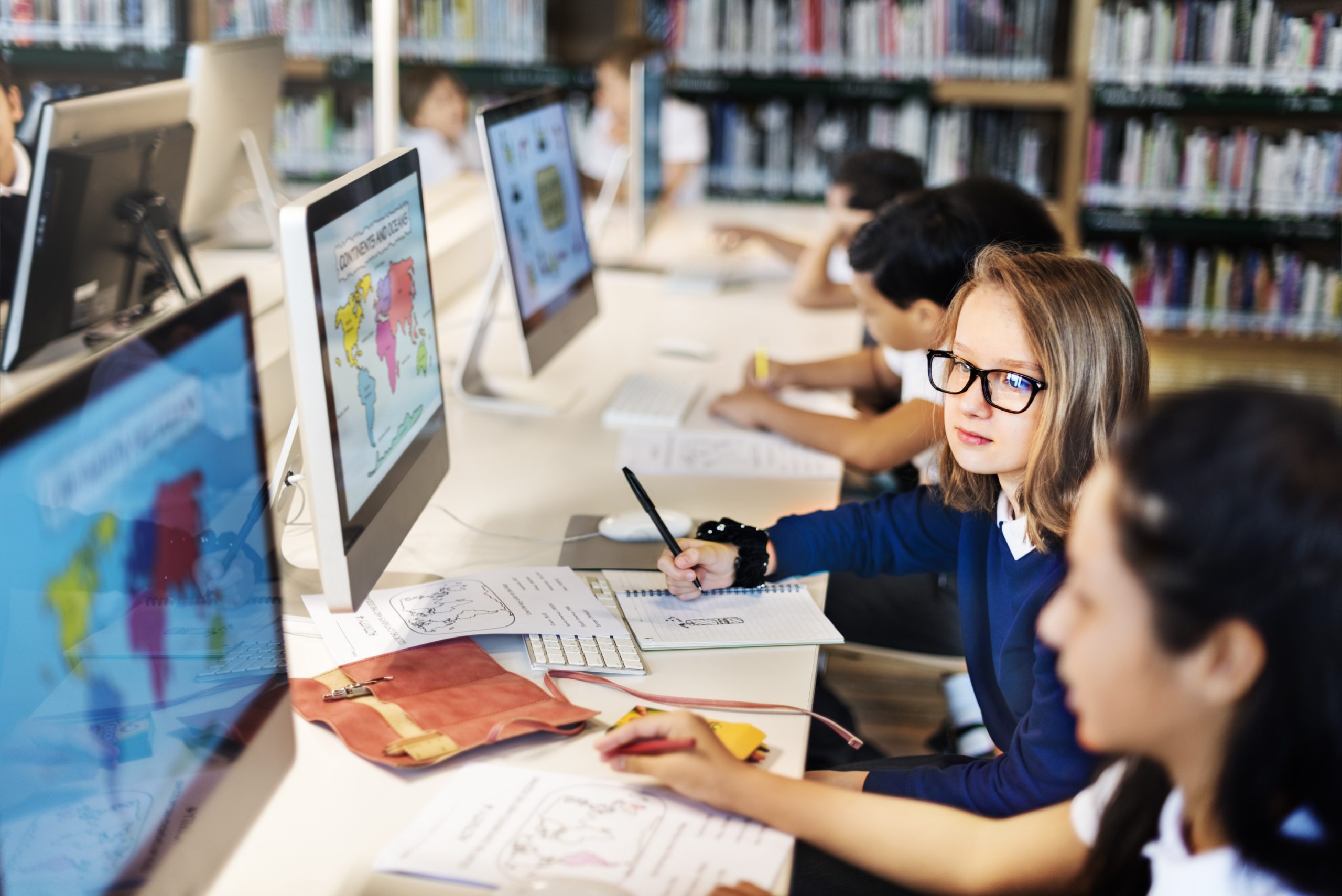 Students interacting with computer technology in an educational setting.