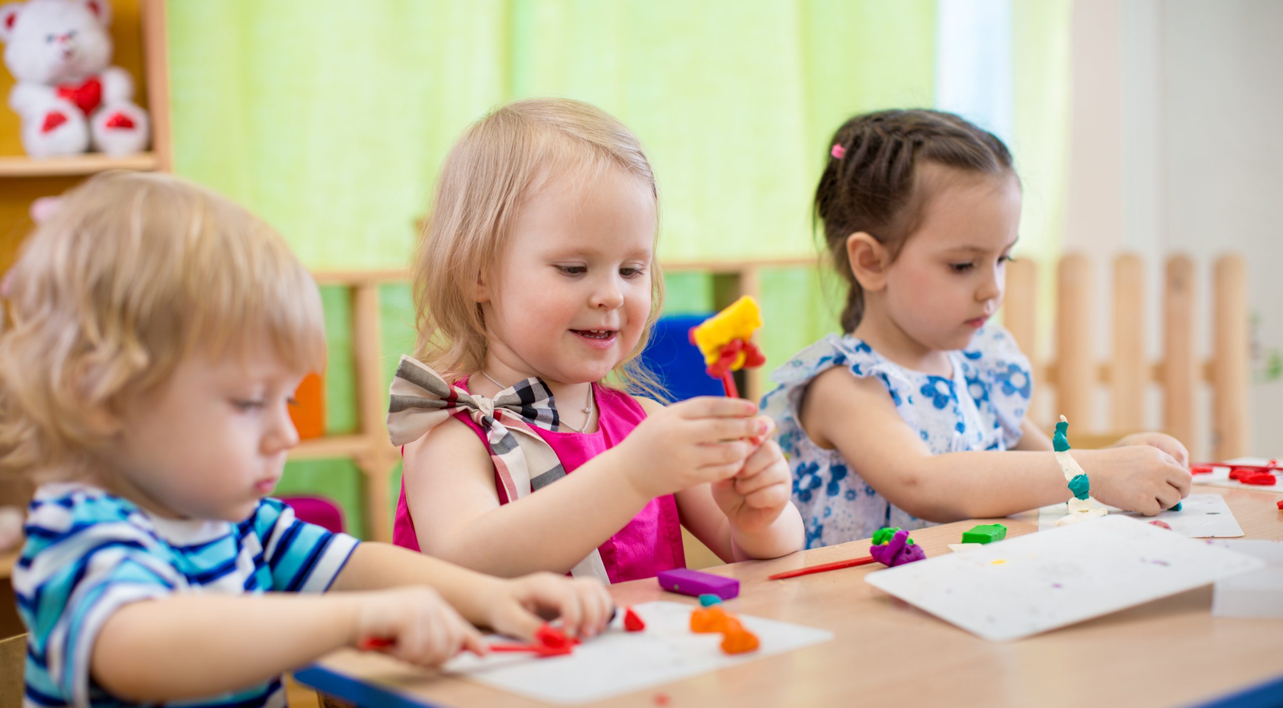 Kids engaged in arts and crafts activities, using colorful materials in a classroom setting.