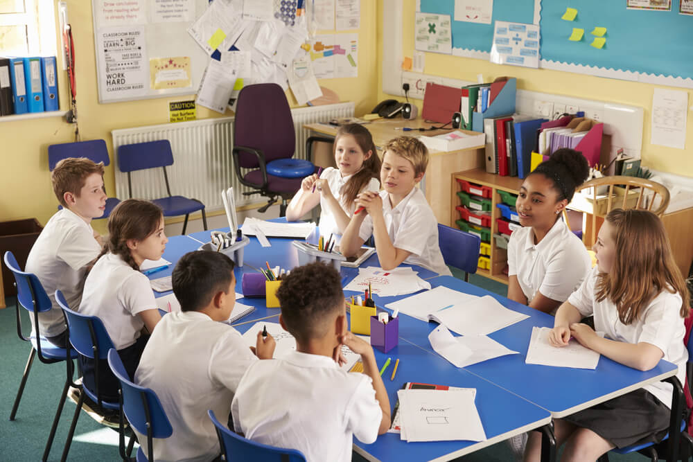 Group dynamics at work in a classroom setting as children collaborate on a group activity