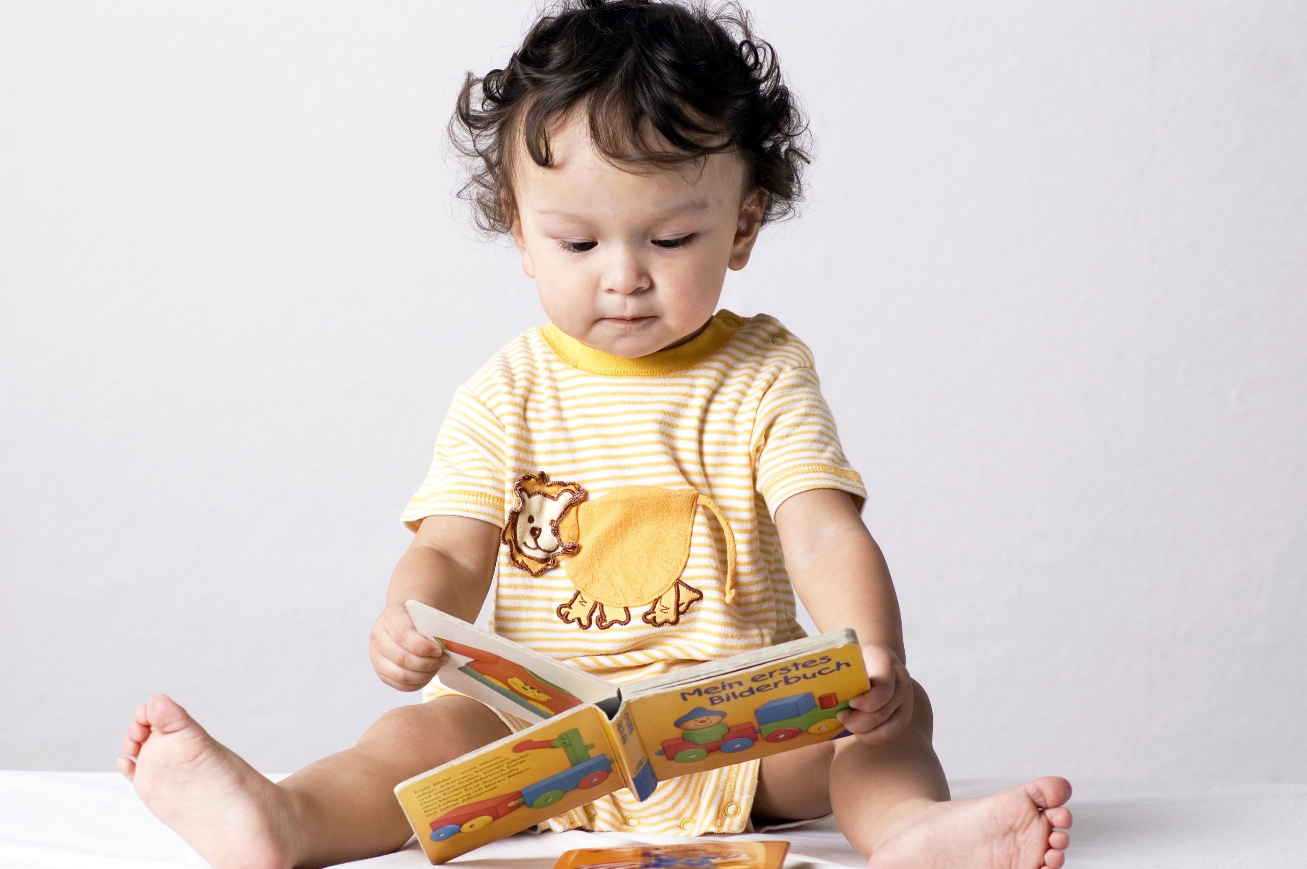 A child considers the first book with pictures, representing the second of Bruner's three modes of representation.