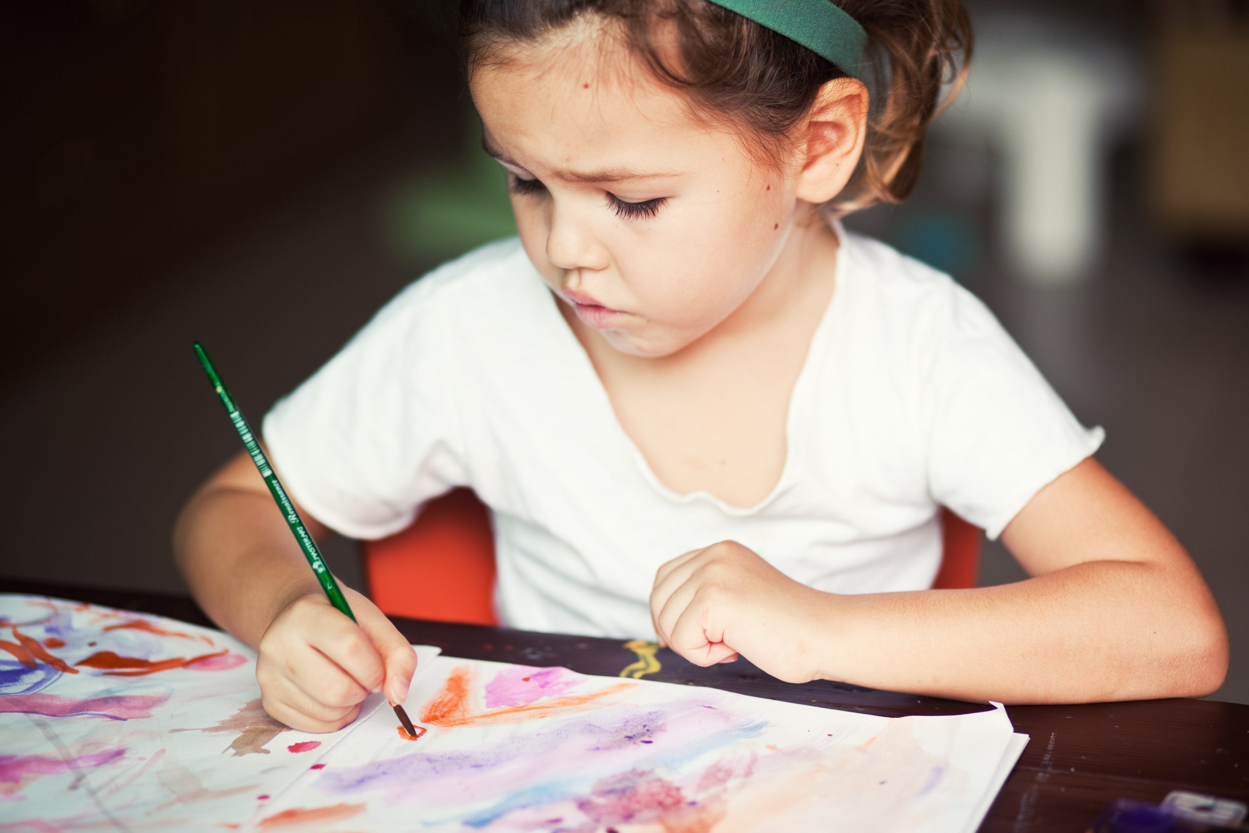 A child deeply engrossed in drawing a picture, illustrating intrinsic motivation through artistic expression