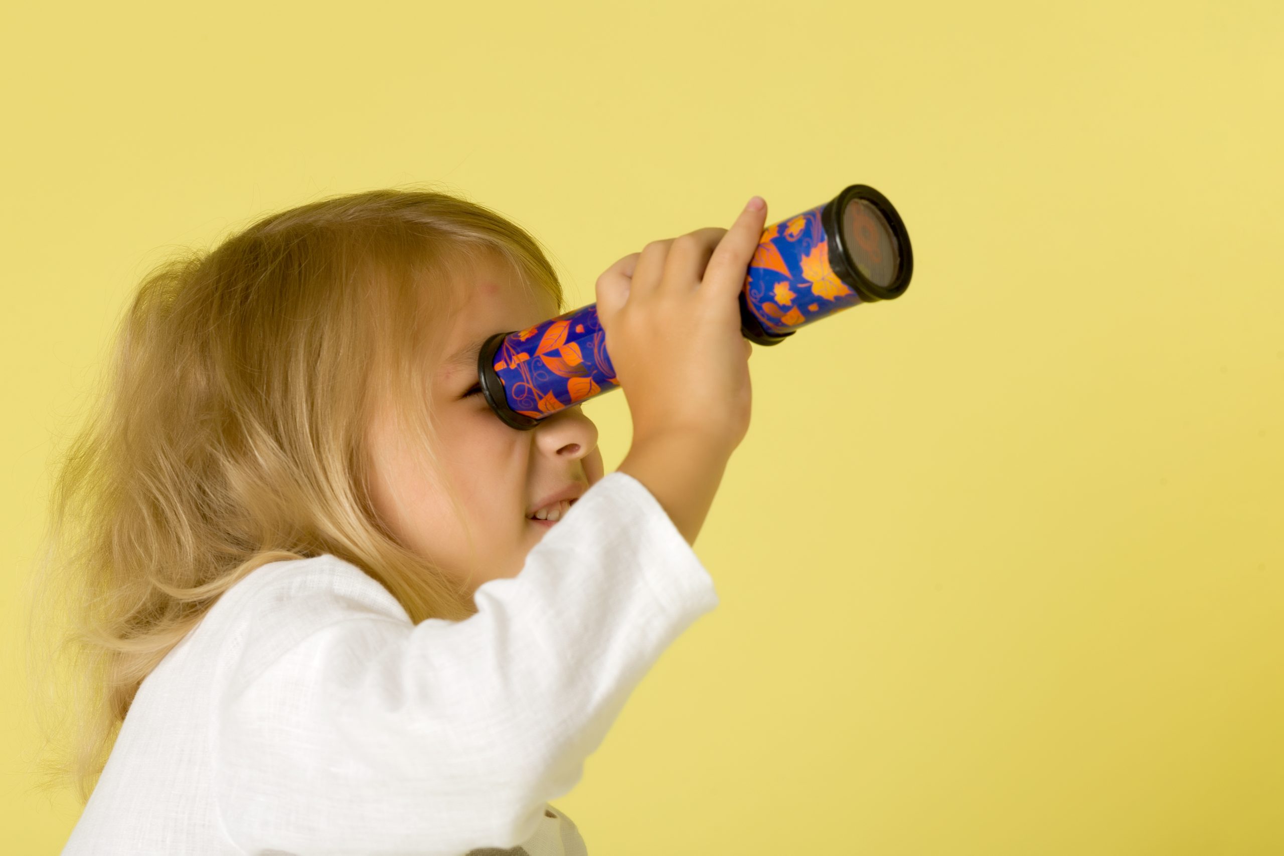 Child peering through a kaleidoscope, representing the myriad perspectives attainable through decentering.