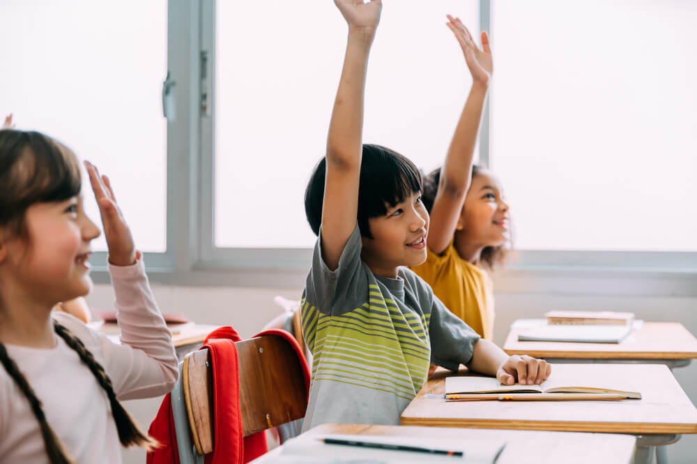 Engaged students raise their hands. 